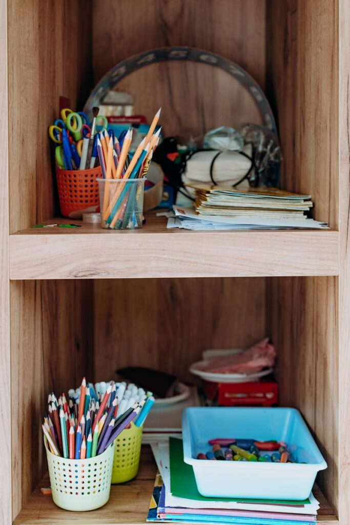 A variety of art supplies on wooden shelves, perfect for creative projects.